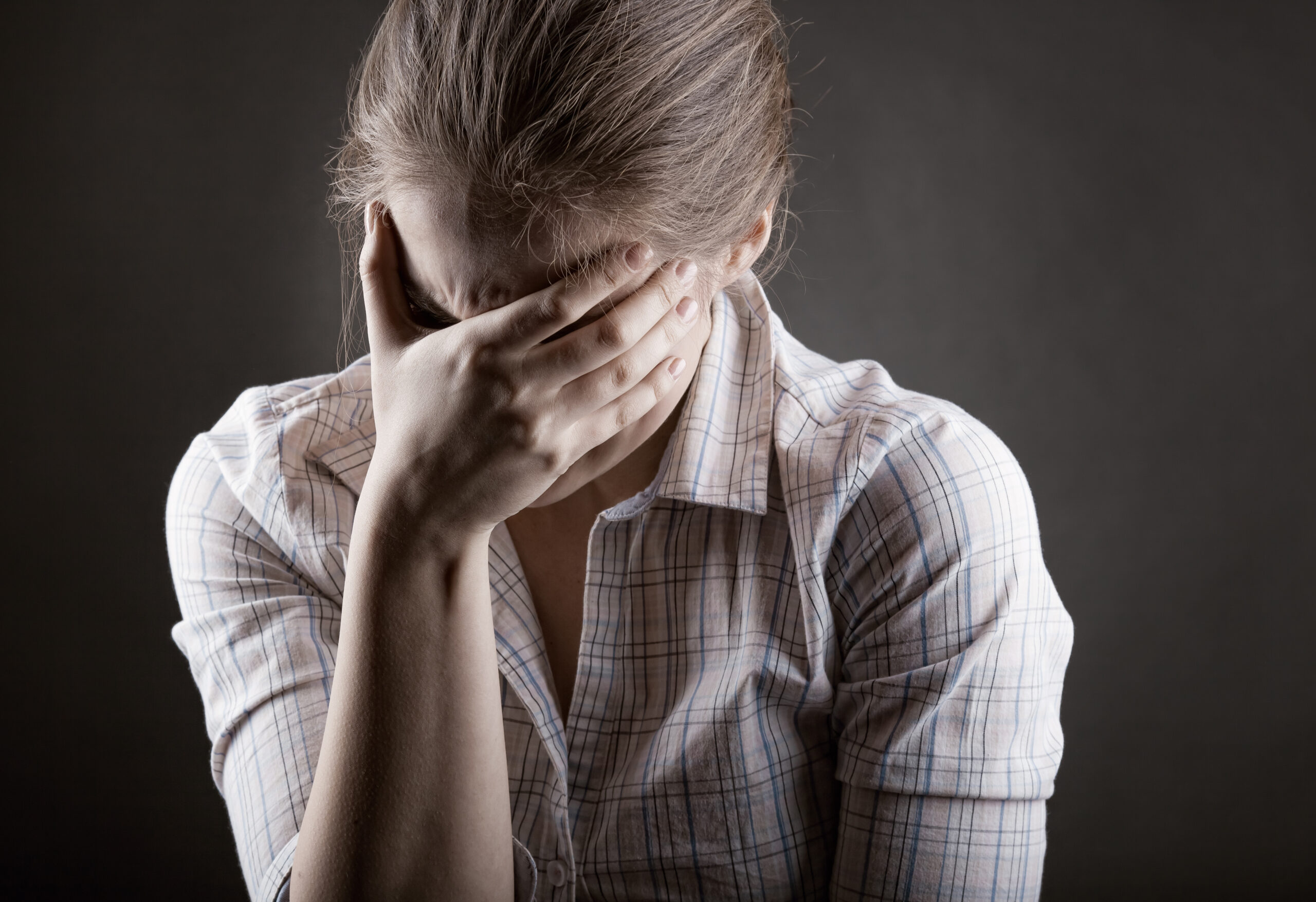Young crying woman on a dark background