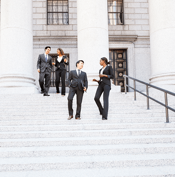 Four well dressed professionals walk down